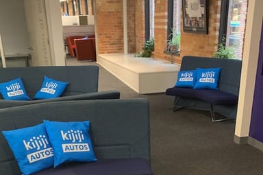 Couches with the Kijiji Autos logo on pillows in the office